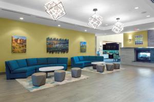 凤凰城菲尼克斯机场南部希尔顿惠庭套房酒店的大堂设有蓝色的沙发、桌子和壁炉。