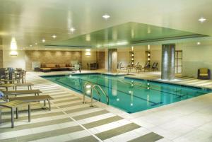 雷丁瑞丁希尔顿逸林酒店的一座配有桌椅的酒店游泳池