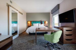 埃德蒙顿Hampton Inn & Suites Edmonton St. Albert, Ab的酒店客房配有书桌和床。