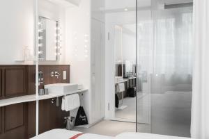 伦敦Ruby Stella Hotel London的带淋浴、盥洗盆和镜子的浴室