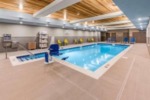 北康威Home2 Suites By Hilton North Conway, NH的医院里的一个游泳池,有黄色的椅子