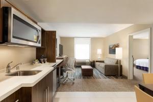 Menomonee FallsHome2 Suites By Hilton Menomonee Falls Milwaukee的酒店客房设有厨房和客厅。