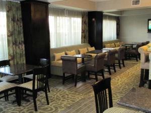 Lindale林代尔/泰勒希尔顿恒庭酒店的餐厅设有桌椅和沙发。