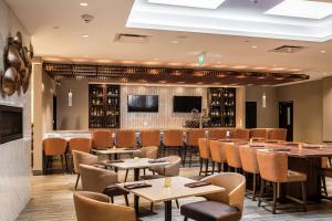 基奇纳DoubleTree by Hilton Kitchener的一间带桌椅的餐厅和一间酒吧