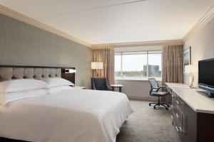 费城费城城市大道希尔顿酒店的酒店客房设有一张大床和一台电视。