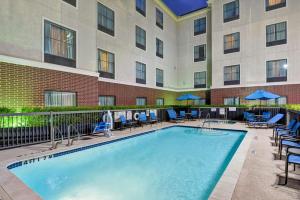 休斯顿休斯顿西能源走廊希尔顿霍姆伍德套房酒店的游泳池,带椅子和遮阳伞