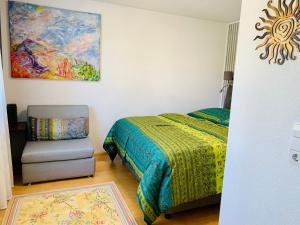 卡尔斯鲁厄AnNa Home & Sunny Home Apartments的一间卧室配有一张床、一把椅子和一幅画