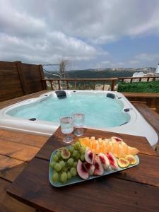 Dāliyat el KarmilT&S suite的游泳池畔桌子上的一盘水果