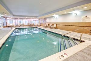 布兰奇堡帕克布里奇沃特/布兰奇希尔顿惠庭套房酒店的医院里的一个大型游泳池,配有桌椅