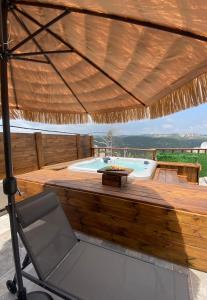 Dāliyat el KarmilT&S suite的大型木制甲板配有热水浴池和椅子