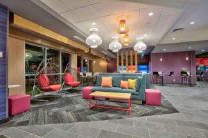 威奇托福尔斯Home2 Suites By Hilton Wichita Falls, Tx的大堂设有蓝色的沙发和色彩缤纷的椅子