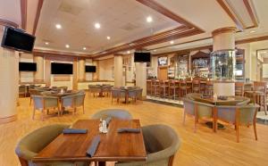 肯纳新奥尔良机场希尔顿酒店的一间带桌椅的餐厅和一间酒吧