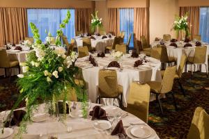 圣达菲圣达菲希尔顿逸林酒店的宴会厅配有白色的桌椅和鲜花
