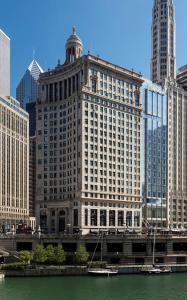 芝加哥芝加哥希尔顿伦敦之家古玩系列酒店的城市里一条河流旁的大建筑