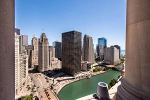 芝加哥芝加哥希尔顿伦敦之家古玩系列酒店的享有河流和建筑的城市美景