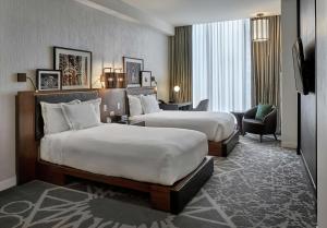 芝加哥芝加哥希尔顿伦敦之家古玩系列酒店的酒店客房,配有两张床和椅子