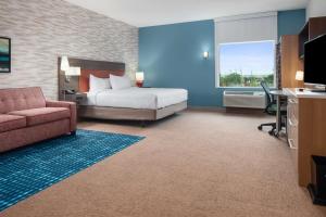 RowlettHome2 Suites By Hilton Rowlett Rockwall Marina的酒店客房配有一张床、一张沙发和一张书桌。
