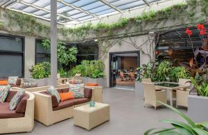 洛杉矶洛杉矶环球影城希尔顿酒店的户外庭院配有沙发、桌子和植物