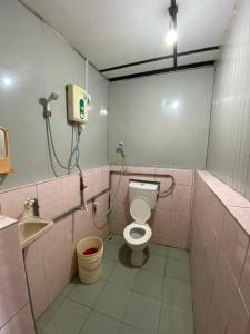 刁曼岛Sri Sentosa Chalet的粉红色的浴室设有卫生间和水槽