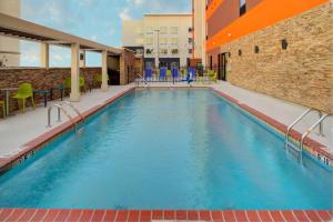 查尔斯湖Home2 Suites By Hilton Lake Charles的蓝色建筑中的一个大型游泳池