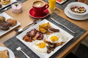 开普敦Protea Hotel Fire & Ice by Marriott Cape Town的餐桌,早餐盘和咖啡