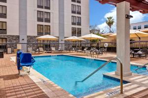 圣安东尼奥圣安东尼奥市中心希尔顿恒庭酒店的游泳池,带椅子和遮阳伞