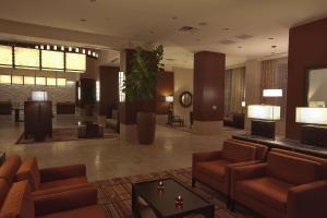 帕姆代尔棕榈希尔顿合博套房酒店的大厅,在大楼里配有沙发和桌子