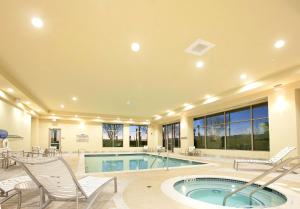 帕姆代尔棕榈希尔顿合博套房酒店的一座带游泳池和椅子的大房子