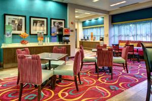 迈阿密迈阿密椰林/科勒尔盖布尔斯希尔顿恒庭酒店的一间铺着地毯的餐厅,配有桌椅