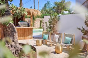 埃斯普霍斯Mar Suites Formentera by Universal Beach Hotels的院子里的一组椅子和枕头