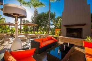 蒙特贝罗洛杉矶蒙特贝罗希尔顿花园酒店的户外庭院配有橙色家具和壁炉
