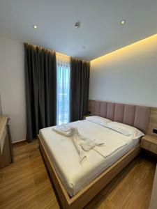 卡萨米尔GL Hotel Ksamil的一间卧室配有一张带粉红色床头板的大床