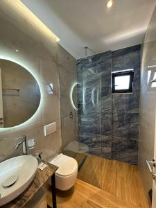 卡萨米尔GL Hotel Ksamil的一间带卫生间、水槽和镜子的浴室