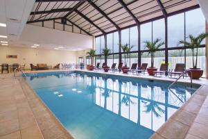 普林斯顿普林斯顿希尔顿逸林酒店的一个带桌椅和窗户的大型游泳池