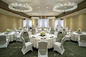 米苏拉密苏拉厄齐沃特希尔顿逸林酒店的宴会厅配有白色的桌椅和吊灯。