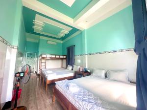 Cu Lao ThuHồng Phú Motel - Đảo Phú Quý的客房设有两张床和风扇。