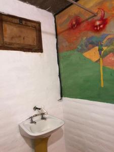 蒂尔卡拉REMODELAMOS casa sobre el rio a 100 mts del mercado municipal的一间带水槽的浴室和墙上的绘画