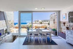 瓦莱塔Valletta Bastions Seafront House的一个带桌椅和大窗户的厨房