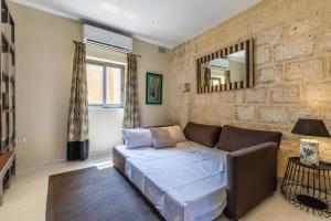 瓦莱塔Valletta Bastions Seafront House的带沙发和镜子的客厅