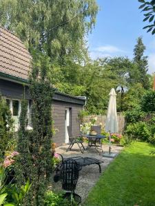 索林根Bergisches Cottage Solingen的一个带桌子和遮阳伞的庭院