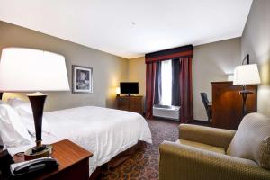 布伦纳姆伦纳姆汉普顿酒店的配有一张床和一把椅子的酒店客房