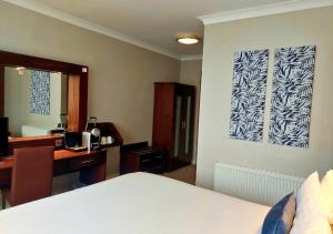戈尔韦弗兰尼瑞斯酒店的一间卧室配有一张床和一张书桌