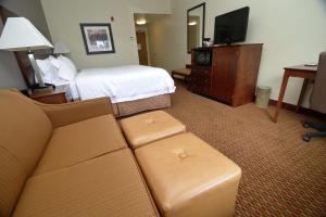 锡福德锡福德汉普顿酒店的酒店客房配有床、沙发和电视。