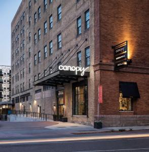 明尼阿波利斯Canopy by Hilton Minneapolis Mill District的一座大型砖砌建筑,上面有公司标志