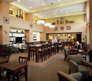北湾诺斯贝希尔顿汉普顿酒店的餐厅里有人坐在桌子和椅子上
