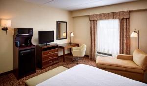 北湾诺斯贝希尔顿汉普顿酒店的配有床、书桌和电视的酒店客房