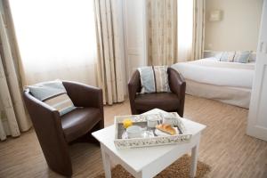 诺亚芒提亚其他三酒店的酒店客房带两把椅子、一张桌子和一张床