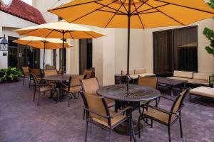 默特尔比奇北林汉普顿酒店的一个带桌椅和遮阳伞的庭院。