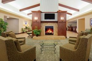 萨克拉门托萨克拉门托机场纳托马斯希尔顿惠庭套房酒店的大堂设有壁炉、椅子和电视。