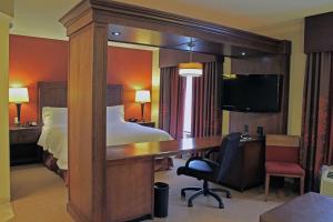 圣路易斯南圣路易斯55号洲际公路希尔顿恒庭旅馆&套房酒店的酒店客房设有一张桌子、一张床和一间卧室。